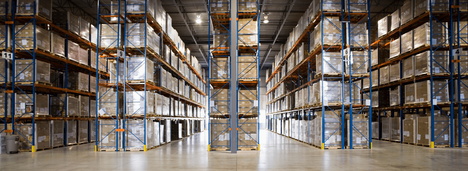 Rows of shelves with goods boxes in huge distribution warehouse at industrial storage factory.